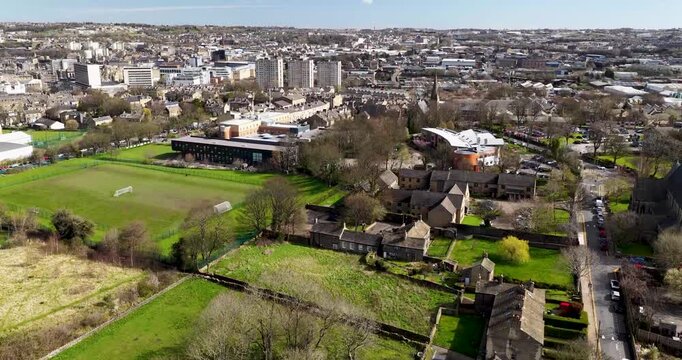 Aerial drone footage of the City of Bradford in Yorkshire in the UK showing the urban skyline historic architecture busy roads commercial districts residential areas and the wider Yorkshire landscape