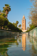 Obraz premium Le reflet dans une fontaine d'eau de la Koutoubia, mosquée historique de Marrakech au Maroc. Le format est vertical.