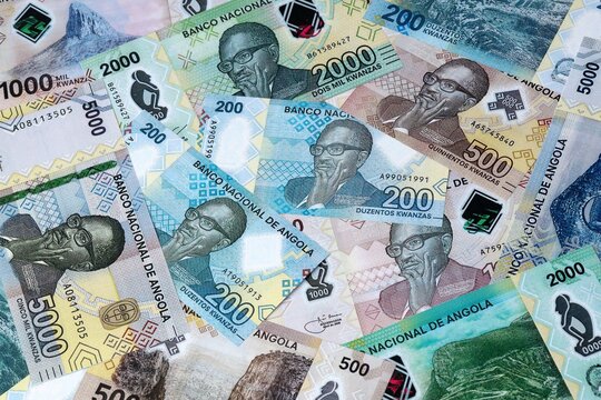 Angolan kwanza money bills in pile on table. Angola AOA currency cash close up