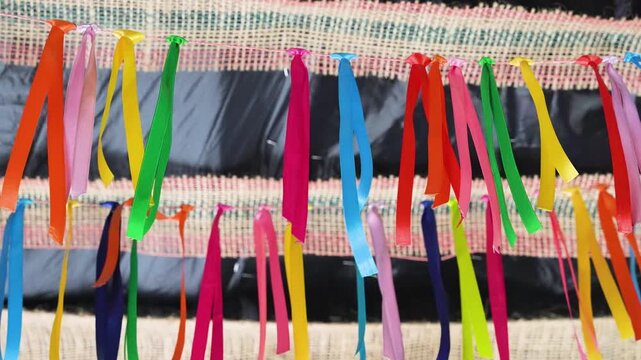 Vibrant multi-colored ribbons tied to a string garland for a festive celebration background.