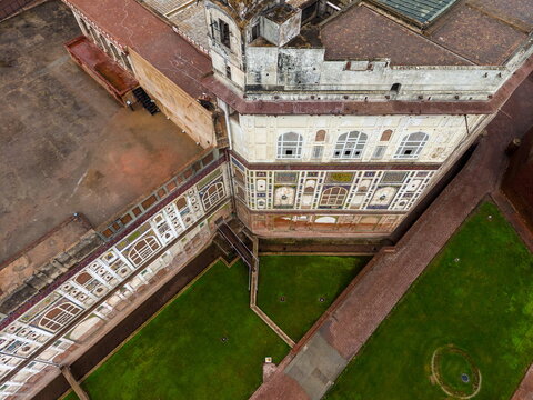 Aerial view of the historic Lahore Fort featuring intricate tile work, ancient stone walls, and manicured green lawns in Lahore, Punjab, Pakistan.