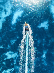 Obraz premium Aerial drone view of beautiful floating boat in blue sea on sunny day in summer. Mallorca island, Spain. Top down view of speed boat, sea, turquoise water. Travel. Tropical landscape. Yachting. Cruise