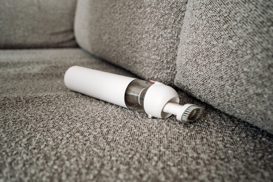 Small cordless vacuum cleaner in living room on the sofa