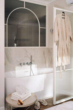 Freestanding bathtub in a modern hotel room with simple bathroom decor