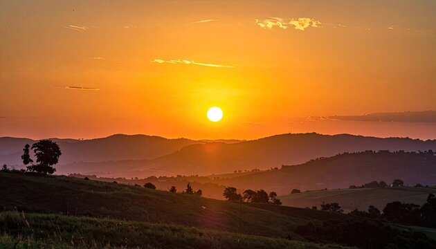 Vibrant Sunset Over Rolling Hills and Distant Mountains.
