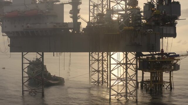 Aerial view of offshore jack up rig and offshore platform during sunset for oil and gas exploration and production. 
