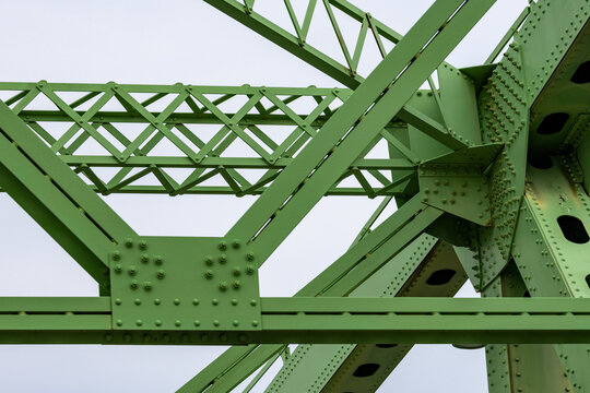 Gaspesie, Quebec, 06 June 2026 : Green painted metal bridge structure features riveted beams and diagonal trusses against a bright sky.