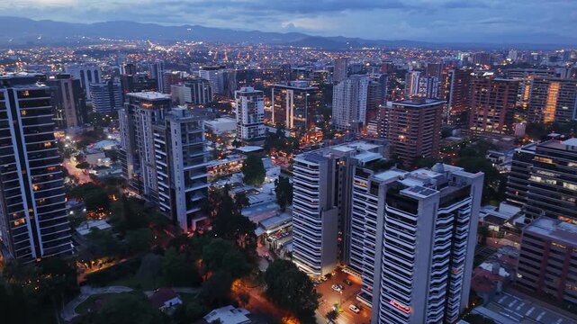 Vista de altura de Ciudad de Guatemala con rascacielos residenciales y luces urbanas de noche. Atardecer dram&aacute;tico y colorido sobre el horizonte de la Ciudad de Guatemala.