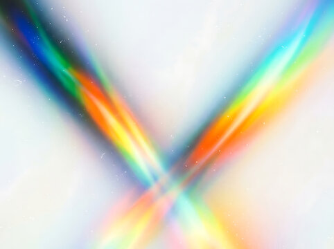Vibrant rainbow colored light beams intersecting on a soft white background with sparkling particles