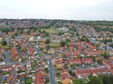 Aerial view of a residential neighborhood in Dewsbury, featuring rows of red-brick houses, a roundabout, and suburban streets in Dewsbury, Dewsbury, United Kingdom.