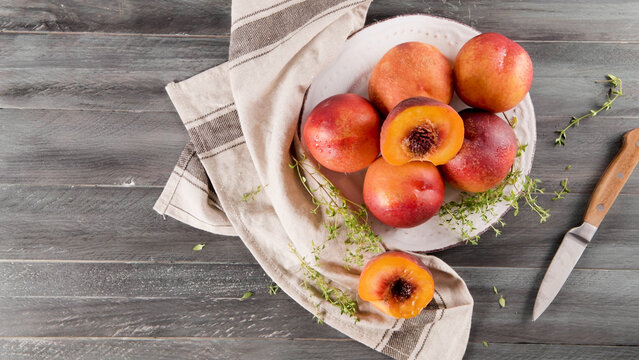 Fresh nectarines on a plate with thyme