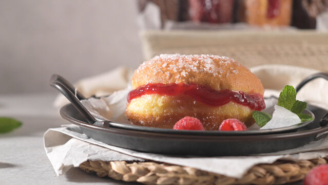Sweet sugared donut filled with red berry jam