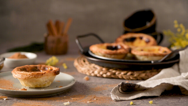 Portuguese egg custard tart on a plate with cinnamon