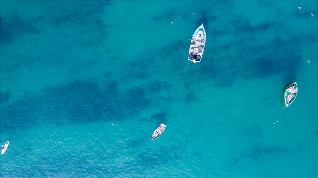 Aerial view of small fishing boats floating on the clear turquoise water near the Malecon de Chorrillos in Lima, Provincia de Lima, Peru.