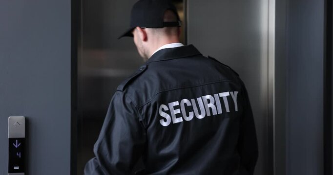Bodyguard using walkie talkie while entering elevator indoors