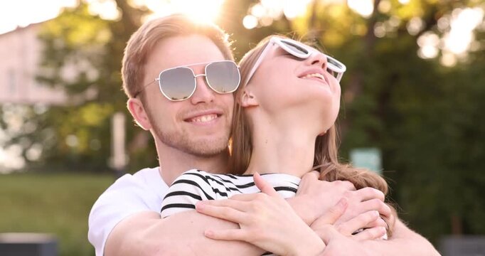 Lovely couple in sunglasses outdoors on sunny day, camera moving in