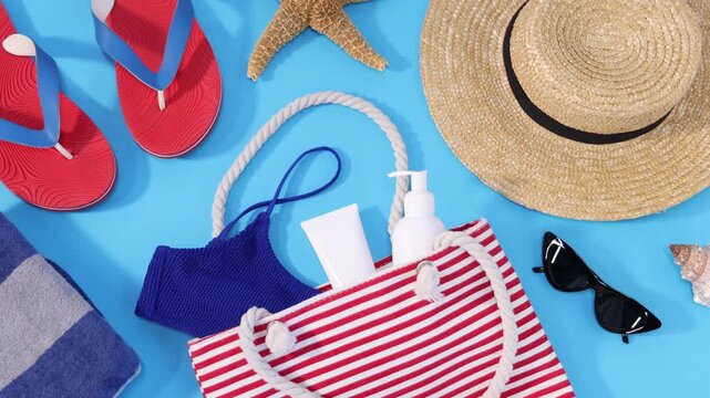 Bag with different beach accessories on light blue background, flat lay