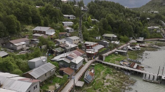 Aerial view of the village of Caleta Tortel, highlighting the characteristic wooden pathways that connect houses along the coastline in Patagonia, Chile.