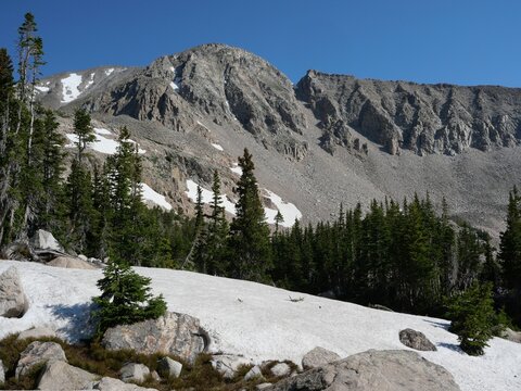 Lingering snow beneath rugged alpine cliffs along the Blue Lake Trail, Colorado