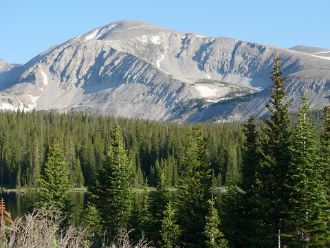 Mount Audubon rising above Brainard Lake and evergreen forest in Indian Peaks Wilderness, Colorado