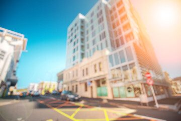 Obraz premium A blurred image of a city street with buildings, cars, and a blu
