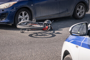 Damaged bicycle after a collision with a car, police car at the accident scene, cyclist accident, road safety, insurance claim and crash investigation © Vladimir Razgulyaev