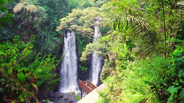 Two beautiful waterfalls Curug Cinulang West Java Indoneisa among rocks and the green scenery of trees 