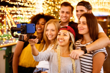 Obraz premium Friends capturing joyful moments with a selfie stick