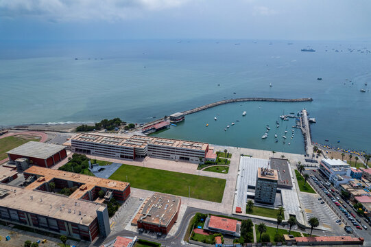Aerial view of the coastal district of La Punta, featuring a harbor with boats, modern buildings, and green spaces in La Punta, Callao Region, Peru.