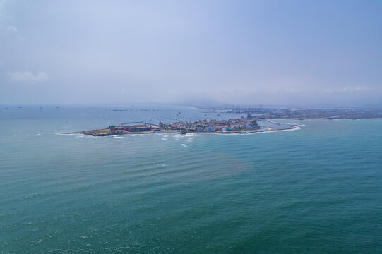 Aerial view of La Punta peninsula extending into the Pacific Ocean with coastal buildings and harbor infrastructure in La Punta, Callao Region, Peru.