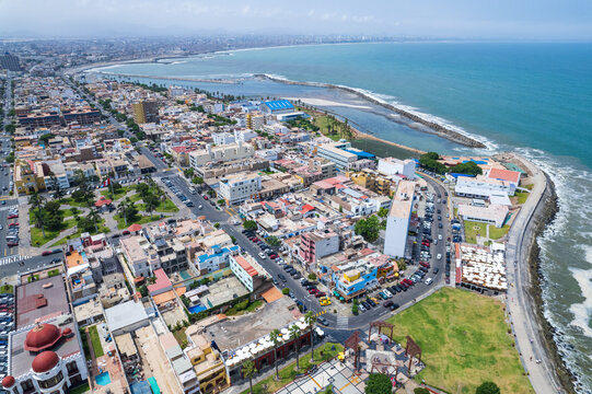 Aerial view of the historic coastal district featuring colorful buildings, a central park, and a scenic promenade along the Pacific Ocean in La Punta, Callao Region, Peru.