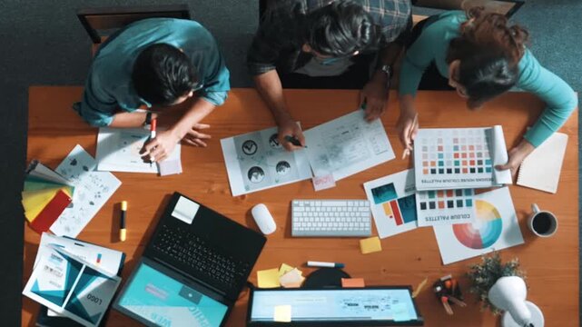 Time lapse of project manager writing idea while team joining meeting and talking about idea. Professional designer design logo while looks at color palette and writing idea down in paper. Symposium.