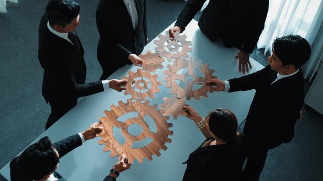 Top view of smart business people gather wooden cog together at meeting. Group of project manager helping and team working to solve problem at meeting room or workplace. Represent unity. Directorate.