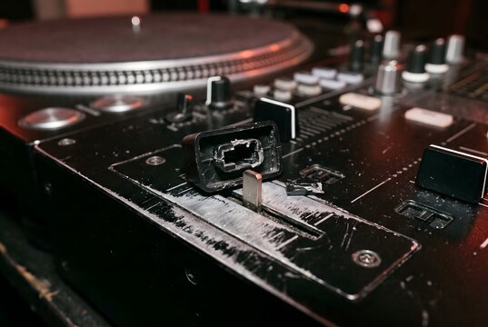 Detached plastic crossfader knob and severe paint wear on a professional DJ mixer