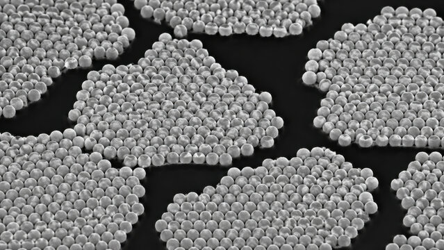 Scanning electron microscopy view of uniform silica sphere clusters arranged in monolayer array, packed spherical particle groups on dark background