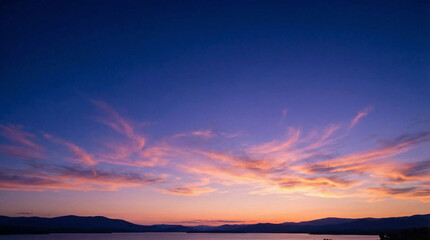 Fototapeta premium Deep Dusk Sky with Wispy Clouds Over Horizon and Water
