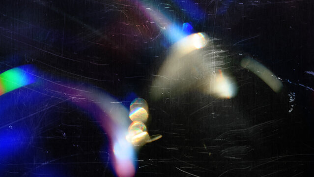 A retro film overlay with rainbow light leaks, scratches and dust on a black backdrop, analog grain and colorful distressed glow with abstract cinematic mood, ultra-realistic, no logos.