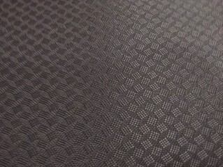 Fototapeta premium Close-up shot of a dark grey synthetic fabric material featuring an embossed geometric diamond grid pattern