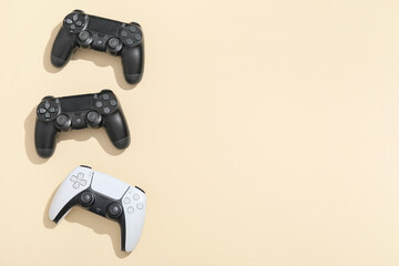 Three video game controllers on beige background © Pixel-Shot