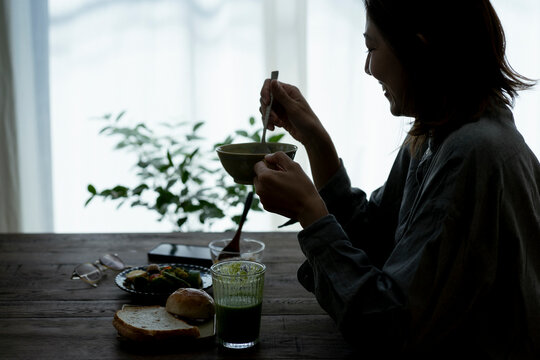 朝食を食べる40代日本人女性のシルエット