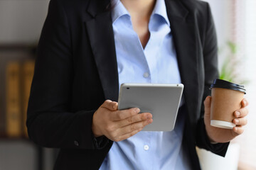 Businesswoman holding tablet and coffee cup © Pixel-Shot