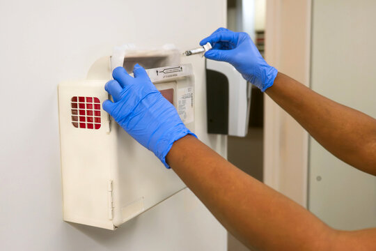 Healthcare Worker Disposing Needle in Sharps Container