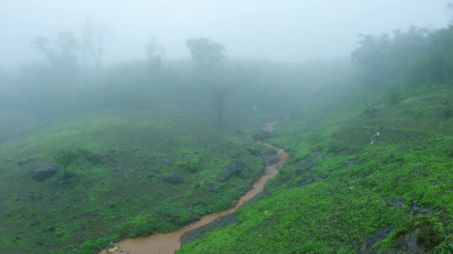 4K shot of a muddy water stream in the Sahyadri hills during the ongoing rain in monsoon season as seen from Saputara in Gujarat, India. Scenic natural background with copy space. Monsoon in Sahyadri.