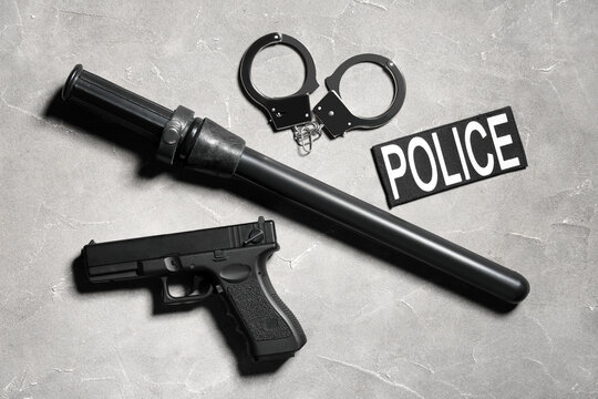 Police equipment including baton, handcuffs, pistol, and badge patch