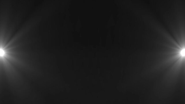Symmetrical bright white light flares emanating from the left and right edges of a dark gray background creating a dramatic and intense visual effect with a central dark void and radiating light beams