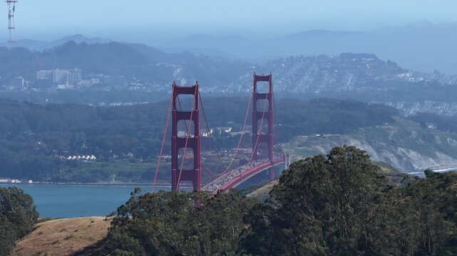 Drone pans to expose the full Golden Gate Bridge, its deck alive with traffic