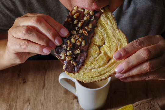 Hands holding food; traditional Mexican pastries and baked goods to enjoy with hot chocolate,coffee or milk. meal to get together with family, woman eating sweet pastry known as "Oreja"