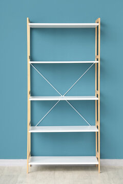 Empty white shelving unit near blue wall