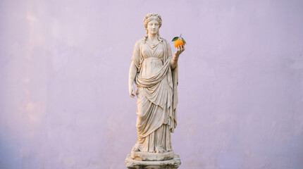 Obraz premium Minimal Classical Greek Goddess Sculpture Holding Orange Fruit with Soft Lighting