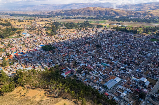 Aerial view of the town of Concepcion, featuring dense residential rooftops, a central plaza, and surrounding agricultural fields in Concepcion, Junin, Peru.